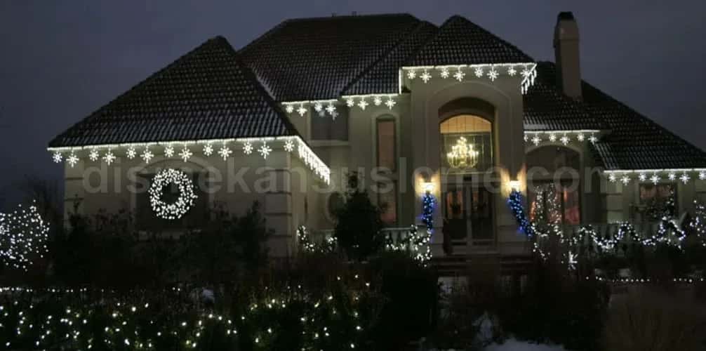 Drone üst çekim 18:15: villa bahçesi geometrik düzen, çatı kenarı LED ve ağaç tepe vurguları