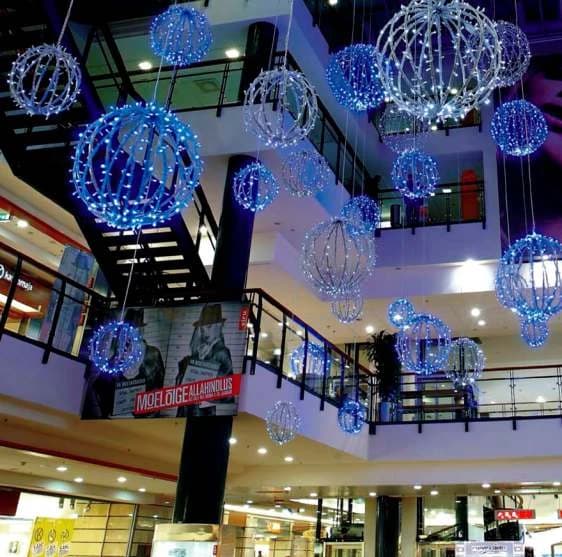 AVM atriumunda tavandan sarkan çok sayıda LED küre, mavi ve beyaz tonlar karışık, farklı boylarda